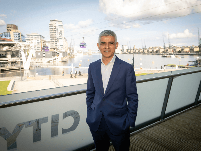 Professional photo of London Mayor Sadiq Khan in front of the Thames waterfront.