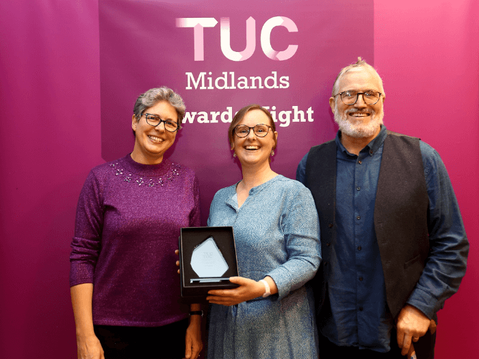 Louise smiling holding the award with Regional Committee member Martha-Ann Brookes and Executive Committee member Nigel Braithwaite.