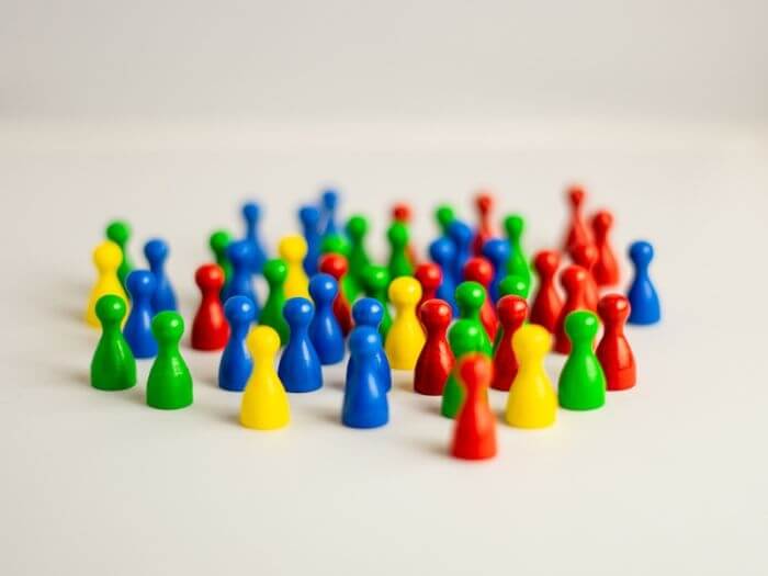 Wooden meeple figures in varying colours, concept of diversity and equality in society.