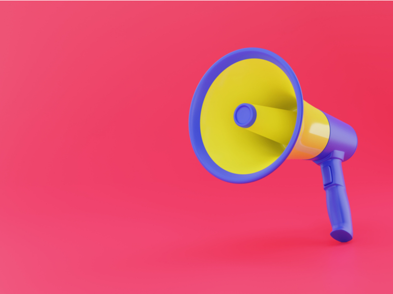 Brightly coloured purple and yellow megaphone facing outwards against a bright pink background.