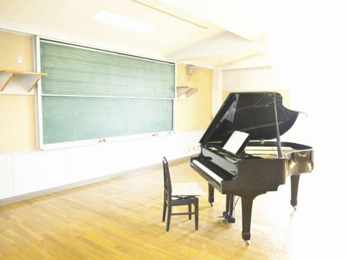 Empty classroom with piano and chalk blackboard.