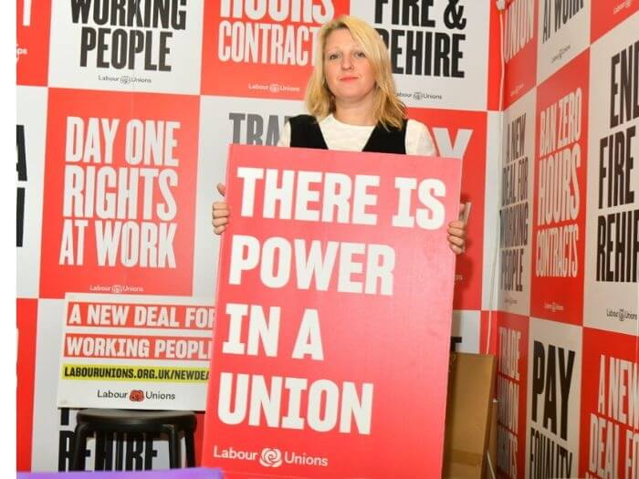 Naomi Pohl at this year's Labour Conference holding a large red sign saying 'There is power in a union'.