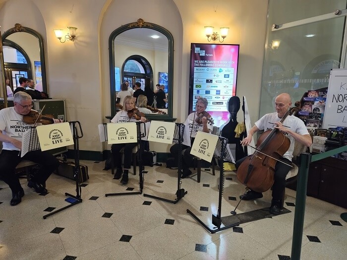 A quartet plays in an entrance foyer, displaying 