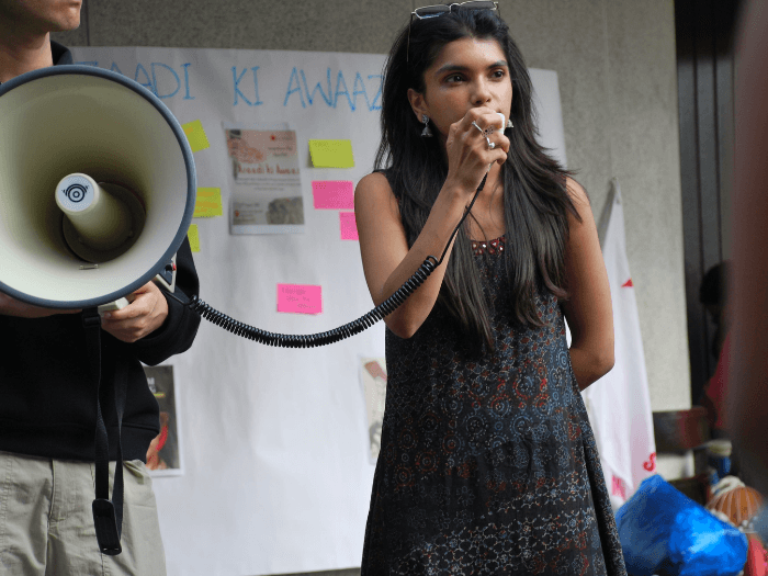 Nupur speaking into a megaphone.