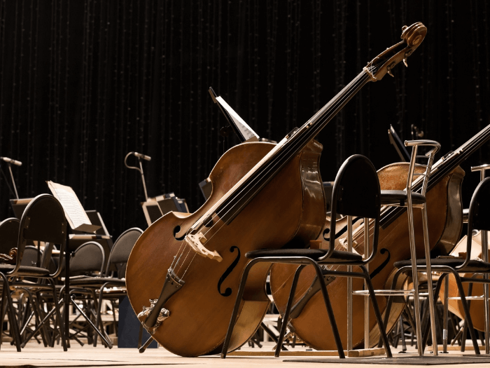 Orchestral instruments on an empty stage.