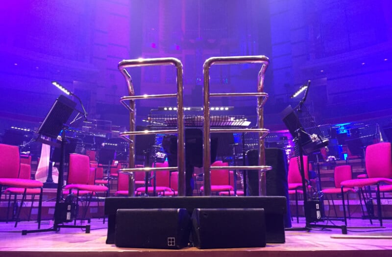An orchestra podium against a background of pink and purple light