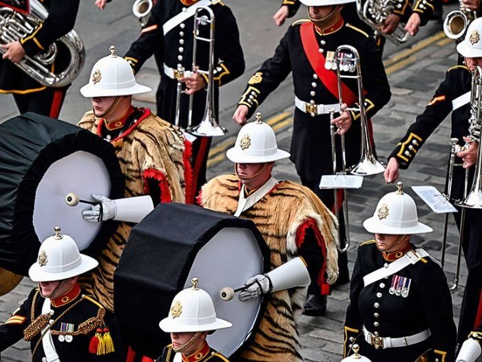 A marching military band on parade in full uniform.
