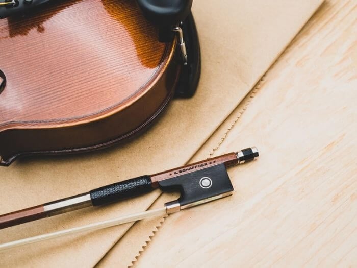 Top view of an acoustic violin and pernambuco wood bow on a tabletop.