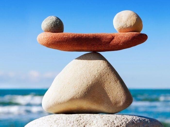 Three rocks balanced on top of each other on the beach, concept of balance and harmony.