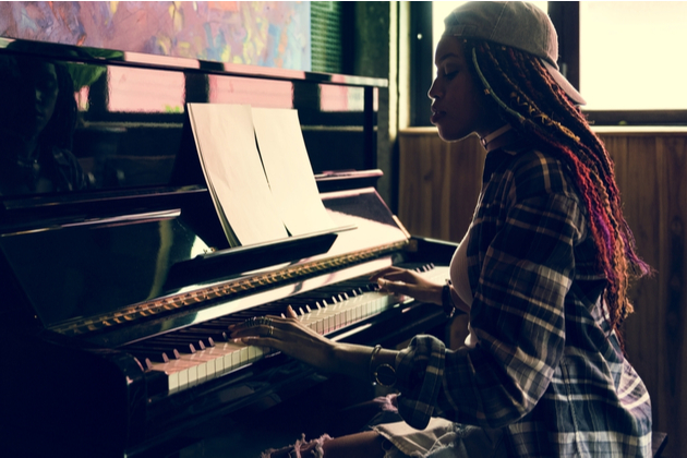 Photograph of a woman sat at a piano.