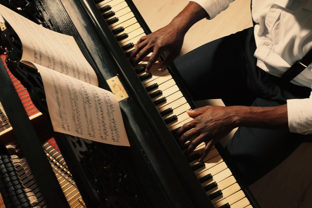 Young black male musician playing piano
