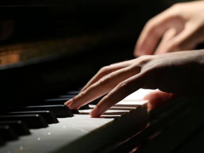 Close up of a women's hand playing piano.