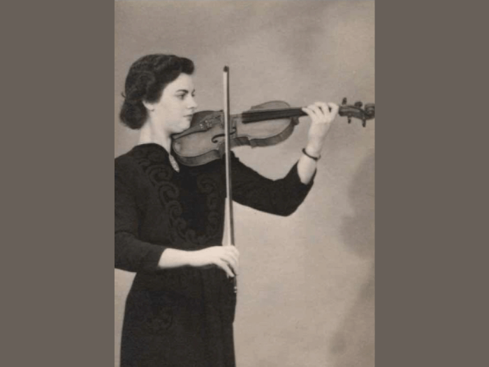 A sepia photo of Pierrette playing violin when she was a young women.