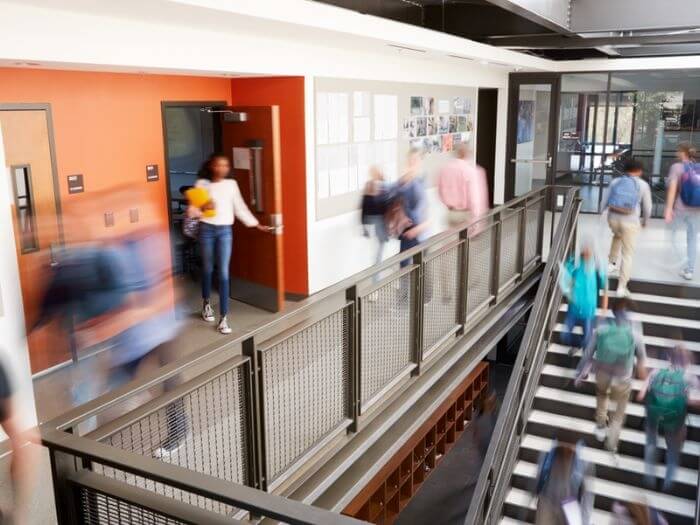 Busy school corridor with motion blurred students and staff.