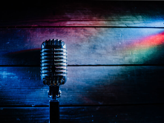 Microphone against a dark background with rainbow light
