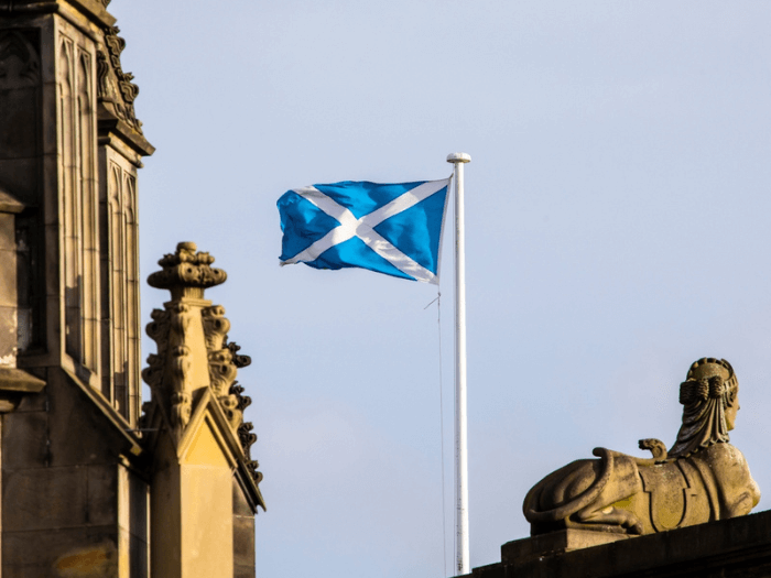 The Scottish flag, flying over an old stone building in Edinburgh.