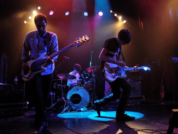 A three-piece band performing on stage.