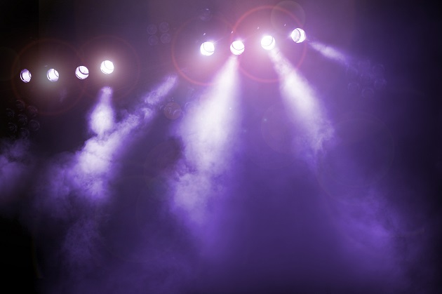 Photo of stage lights shining purple on an empty stage