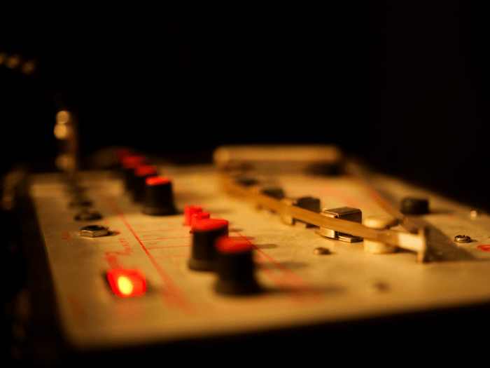 Closeup of a piece of recording equipment against a dark background.