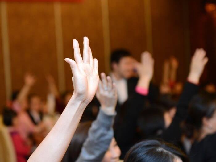 Close up of raised hands for voting.