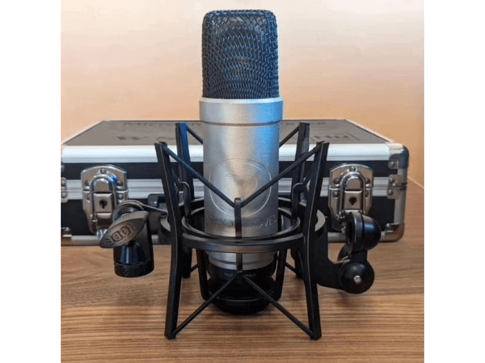 The microphone of peace on a desk in front of its flight case box.
