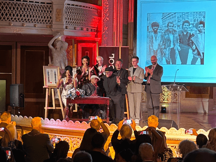 Craig Charles, Richard Kemp CBE, Chris Amoo and Dave Smith, along with their family, on stage at the Awards evening.  The audience are giving a standing ovation.