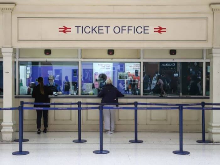Customers bring served at the ticket office inside Marylebone railway station in London.