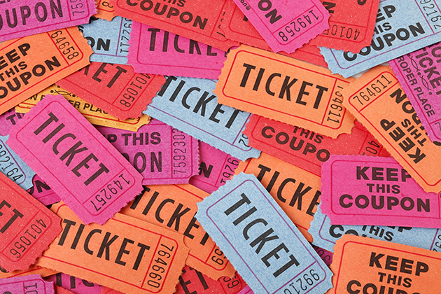 Collect of paper tickets in a pile, coloured orange, dark pink, light blue and red. Each one days ticket in large text on the front with a number for the stub.
