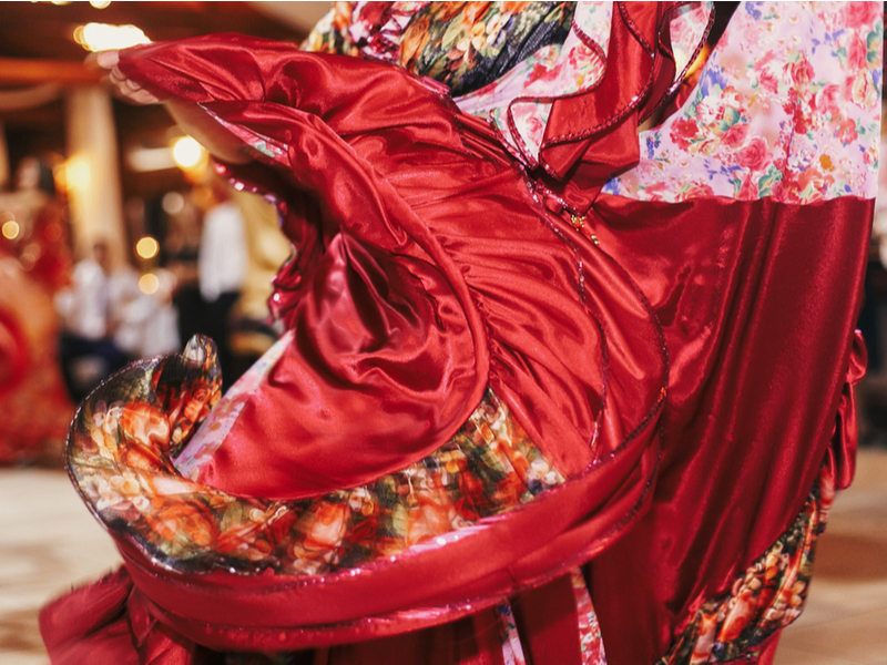 Photograph of a beautiful, swirling red and pattern skirt - part of a dress being worn at a traditional Roma dance.