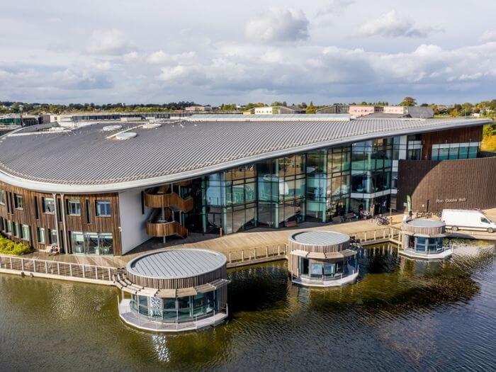 Exterior shot of the Ron Cooke Hub building, by the lake at The University of York Campus East.