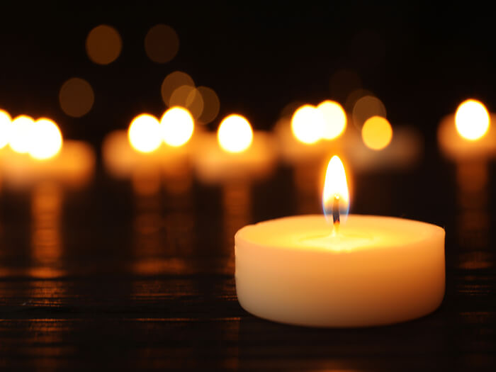A candle in soft focus, representing a vigil.