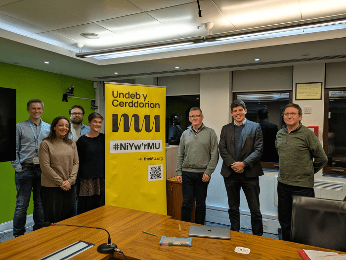 MU members and Senedd candidates infront of an MU banner.