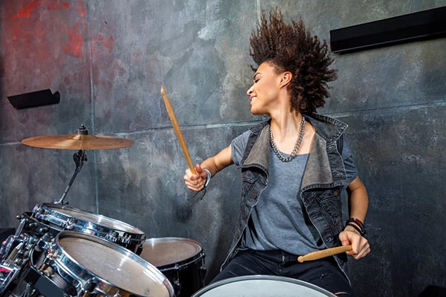 Photograph of woman playing on drum kit
