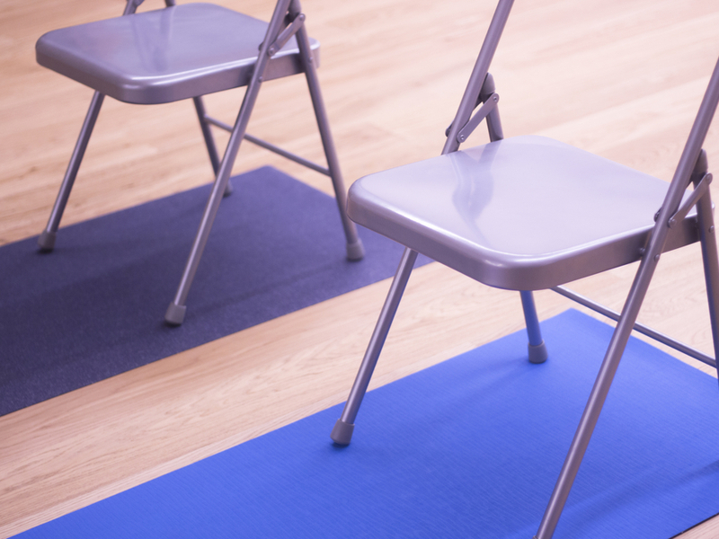 2 silver fold up chairs on blue yoga mats.