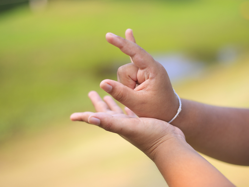 A small child is signing in BSL, with just their hands and arms in the focus of the camera.