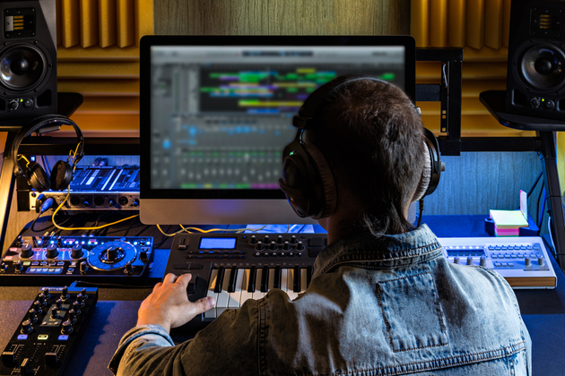 A man producing electronic music in home studio