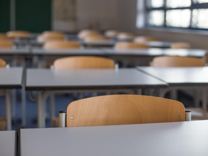 Close up of empty tables and chairs in a classroom.