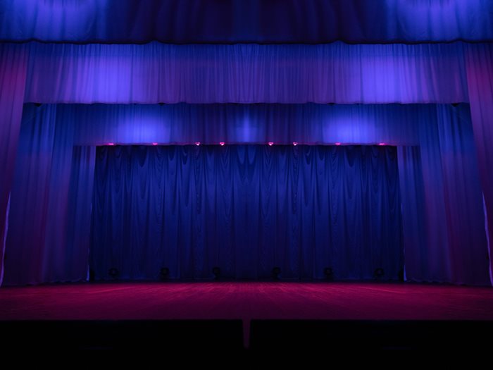 Blue and purple lit curtains on an empty stage