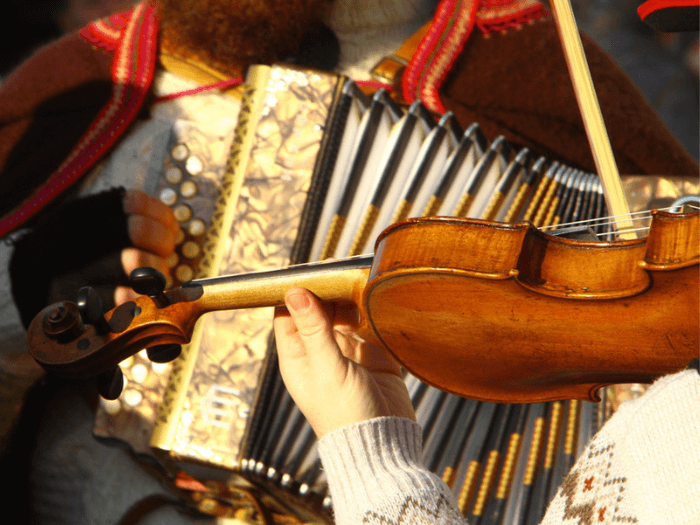 A fiddle player playing with an accordion player as part of a folk music performance.