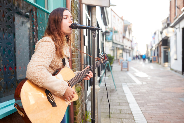 female singer with Acoustic Guitar playing in the Street
