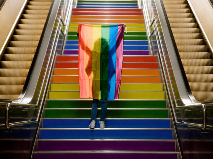 a person holding an LGBT flag on underground