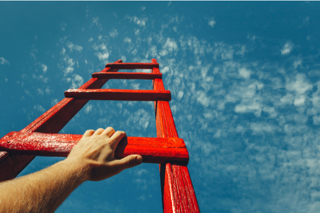 Mans Hand Reaching For Red Ladder Leading To A Blue Sky