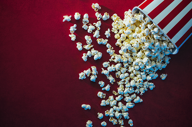 Photograph of popcorn on a red carpet.