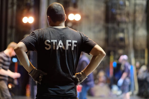 A specialist in the installation of gig stage wearing a 'Staff' t-shirt