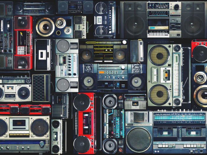 A wall of multi coloured vintage boom box devices